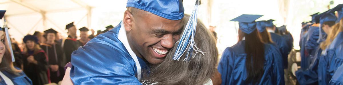 AACC graduate hugs his mentor.